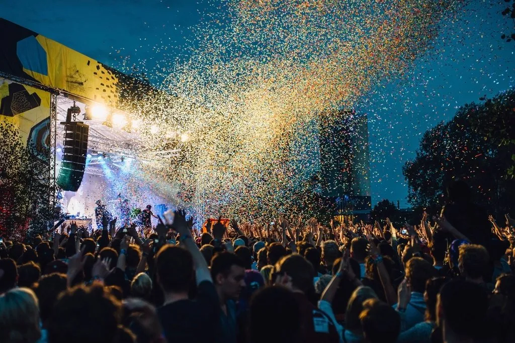 Público en un festival con papel picado cayendo sobre la multitud